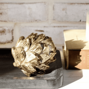 Decorative golden artichoke sculpture on a concrete base.
